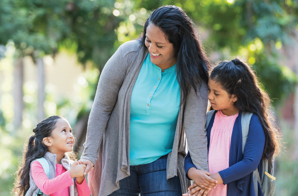 Mother walking daughters to school